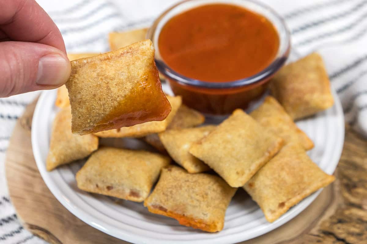 Pizza rolls on a plate with dipping sauce.