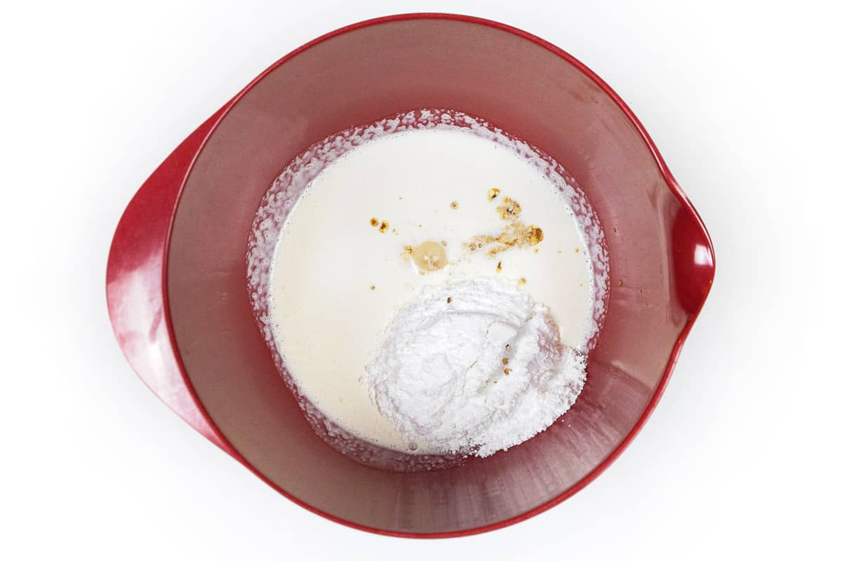 Heavy cream, powdered sugar, and vanilla extract in a large bowl.