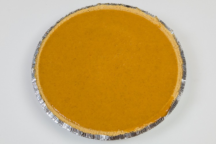 Pumpkin pie filling poured into a pie shell.