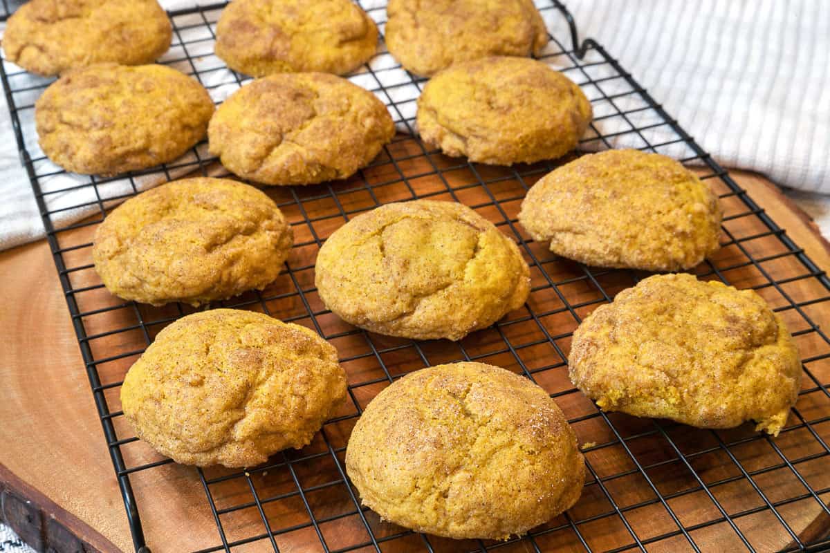 Baked pumpkin snickerdoodle cookies on a cooling rack.