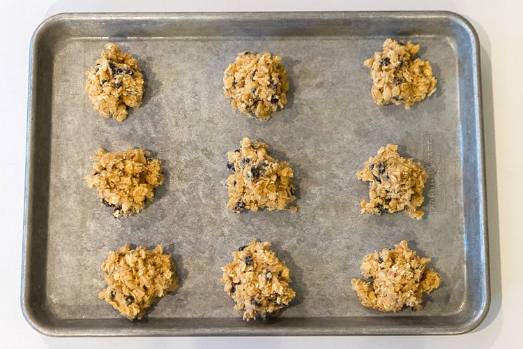 Nine cookie dough balls on cookie sheet.