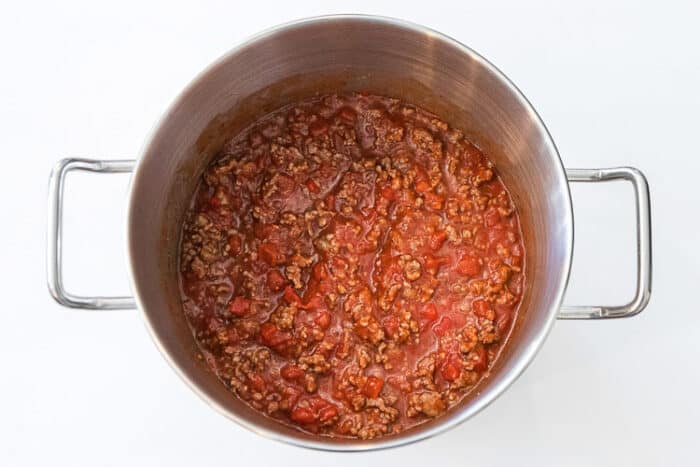 Ground sausage added to tomato sauce mixture.