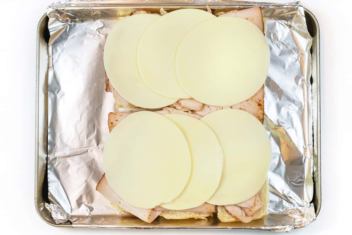 Provolone cheese is laid on top of the turkey.