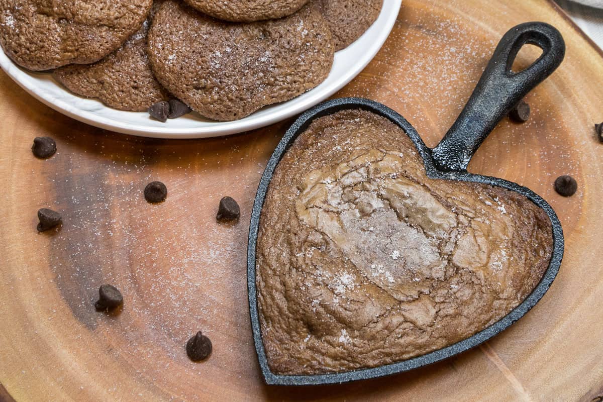 A sea salt chocolate chip cookie in a heart shaped cast iron pan.