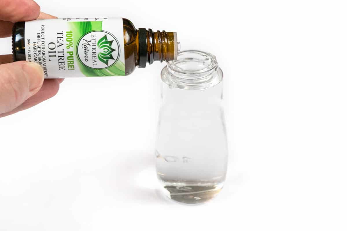 Adding five drops of tea tree oil to the one-hundred milliliter spray bottle together with the water and witch hazel.