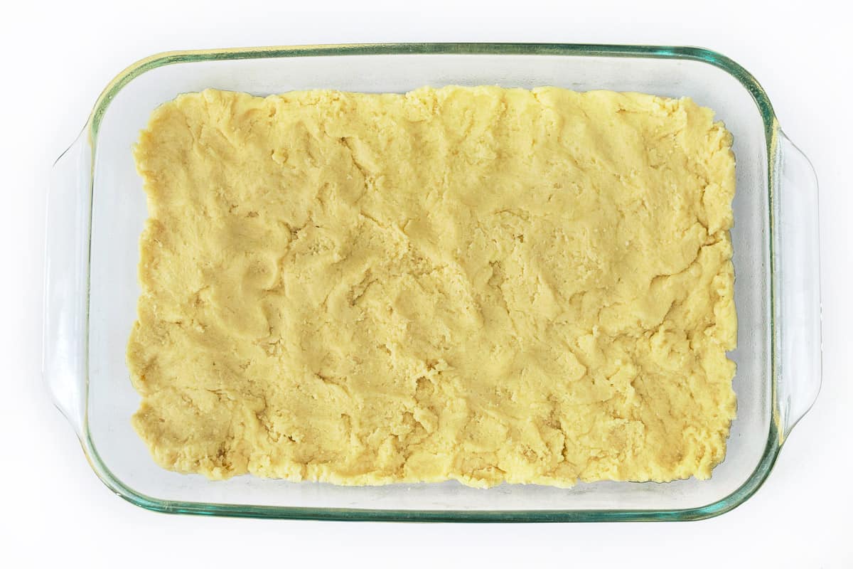 Spread the snickerdoodle cookie dough in the baking pan.