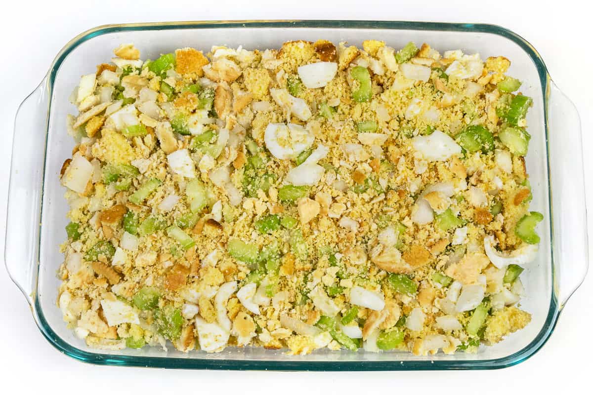 Mix all of the celery, onions, hard-boiled eggs, crumbled Ritz crackers, and crumbled cornbread in the baking dish.