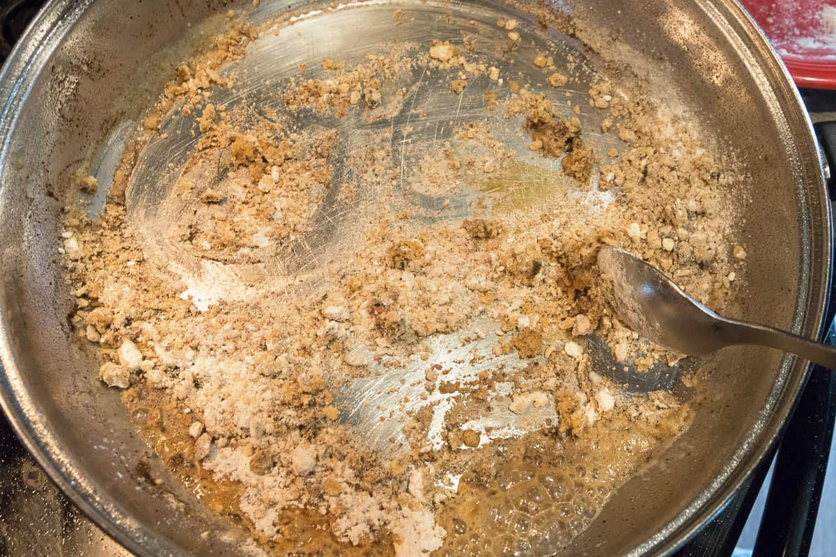 One-fourth cup of flour and one-fourth cup of pork chop drippings in a frying pan.
