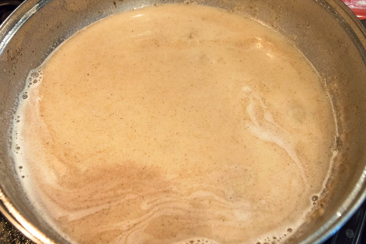 Two cups of water and one-half cup of milk are added to the flour and fat mixture. Cook on medium-high heat until it starts to boil, then turn down to medium heat.