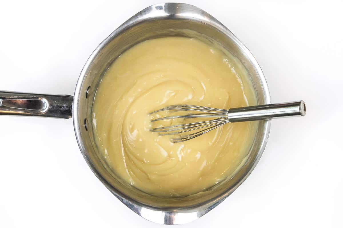 Vanilla extract and butter mixed with the thickened cream mixture in the saucepan.