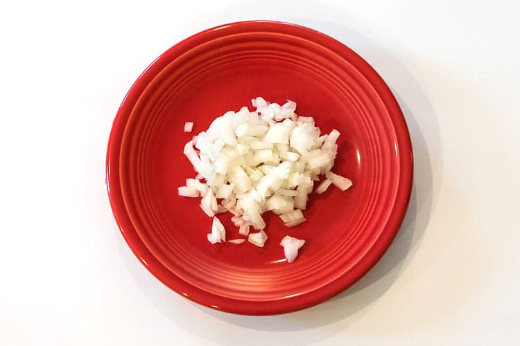 Finely diced onions on a plate for tartar sauce recipe.