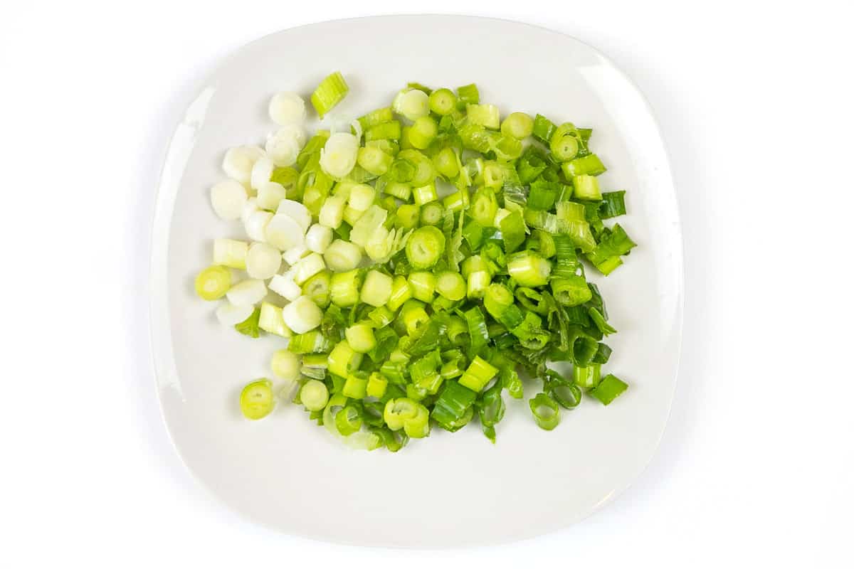 Chopped green onions on a plate.