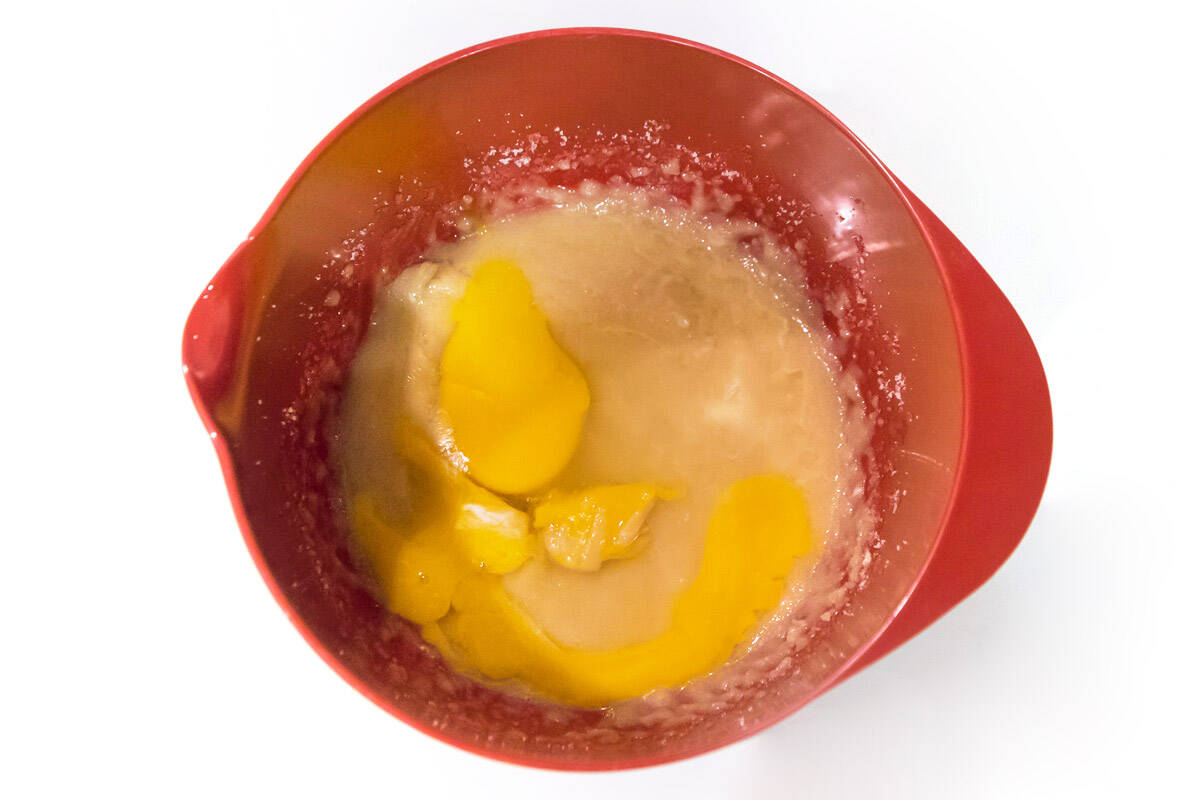 Add two eggs to the butter, sugar, and vanilla extract mixture.