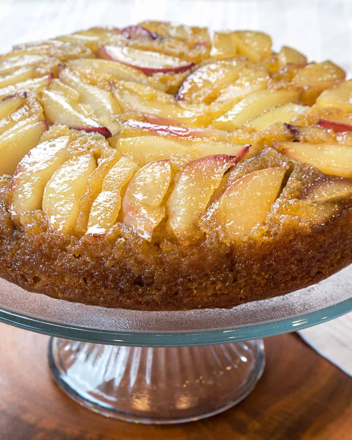 Close up photo of white nectarine cake (upside-down) on a cake stand.