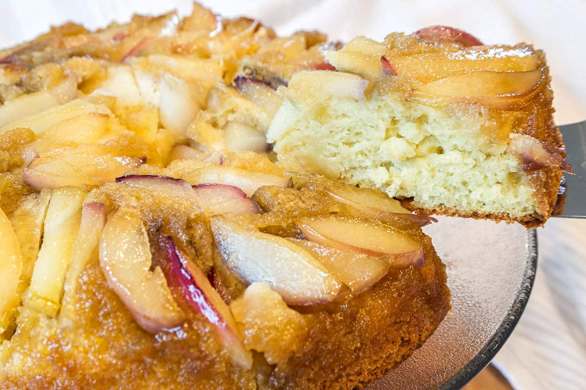 A close up photo of white nectarine cake (upside-down) on a cake stand.